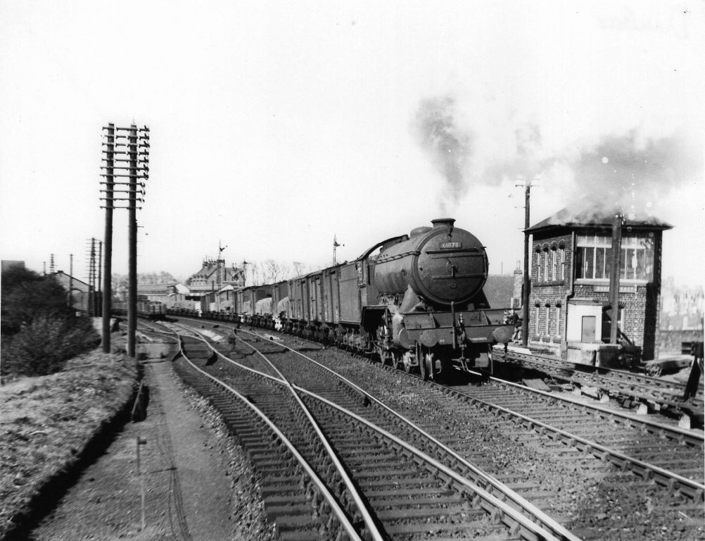 Steam train approaching station from the east.